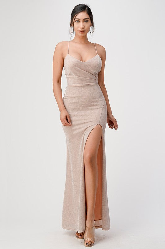 Front view of a blush mermaid gown with spaghetti straps and a side slit.
