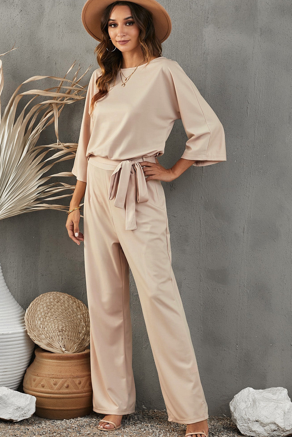 Boat neck apricot jumpsuit with a flattering high waist and elegant design.
