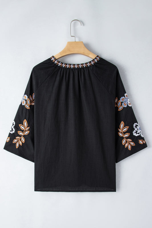 Lightweight black embroidered top with boho-inspired floral patterns
