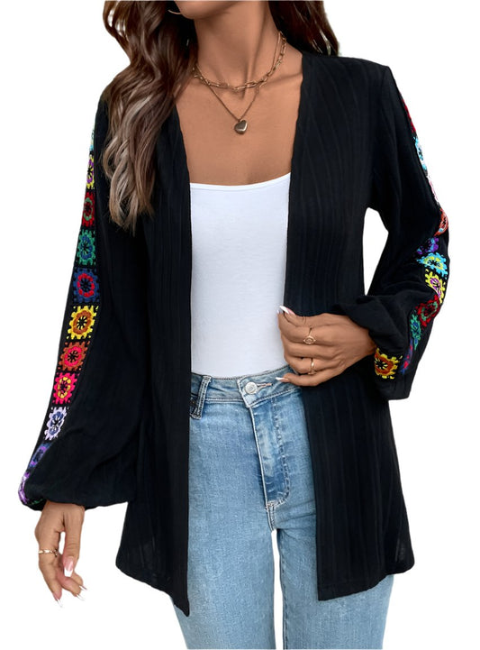 Boho embroidered open-front cardigan in black with colorful floral sleeves.
