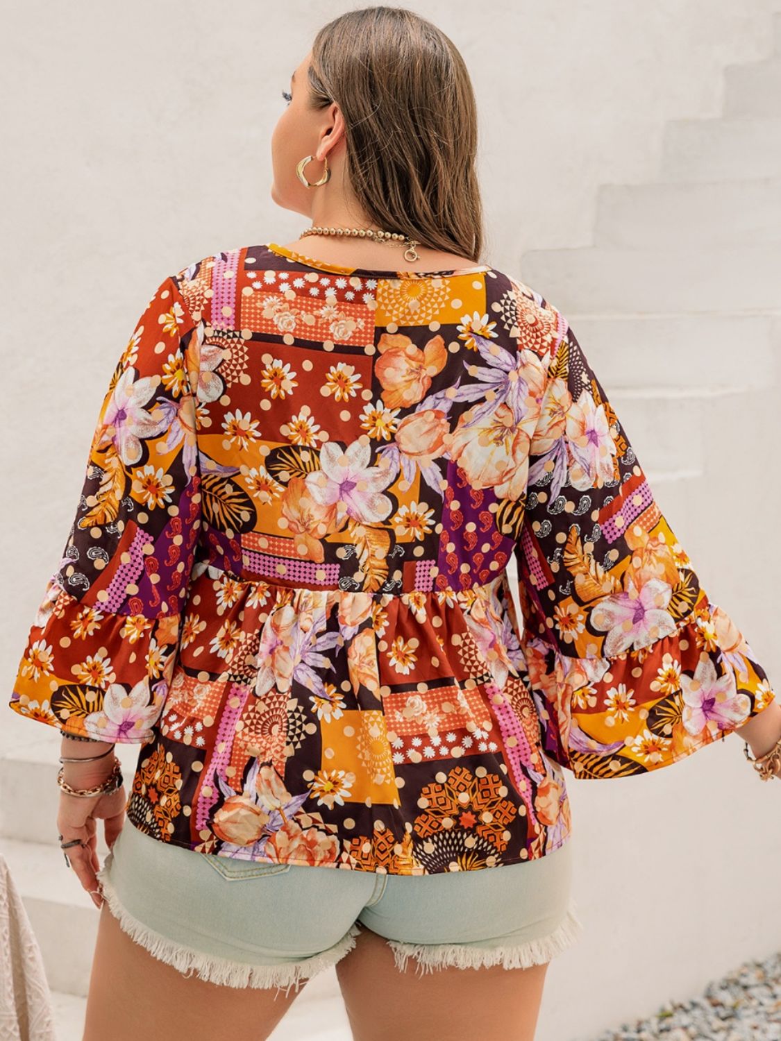 Plus-size floral top in orange and purple with button-down front.
