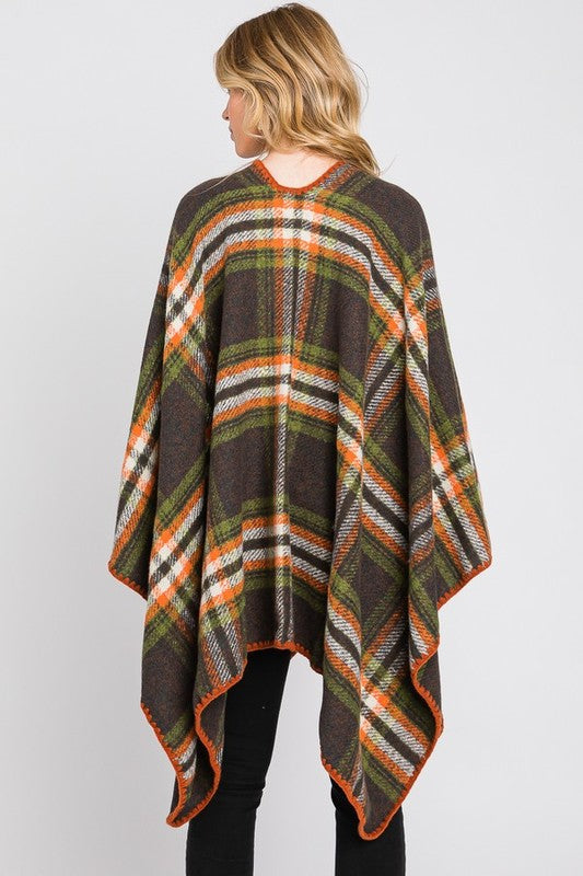 Woman styled in green plaid wrap shawl with relaxed open fit.
