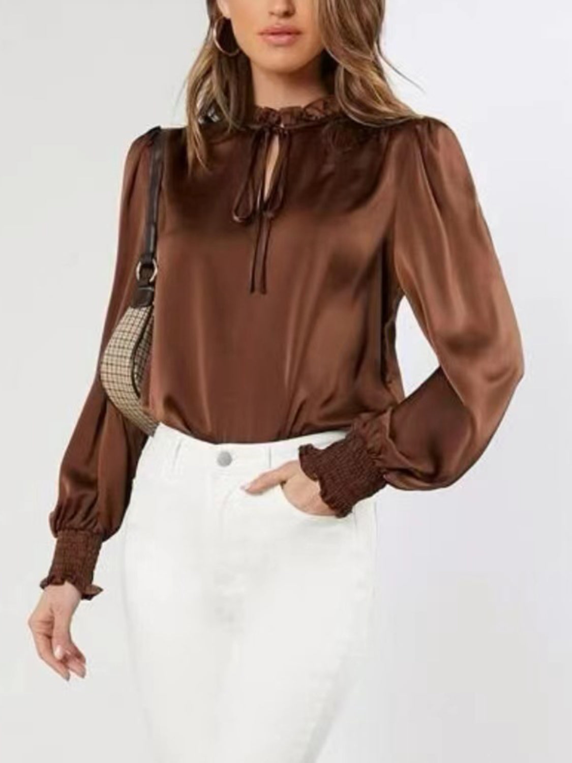 Women’s brown blouse styled with white pants for an elegant look.
