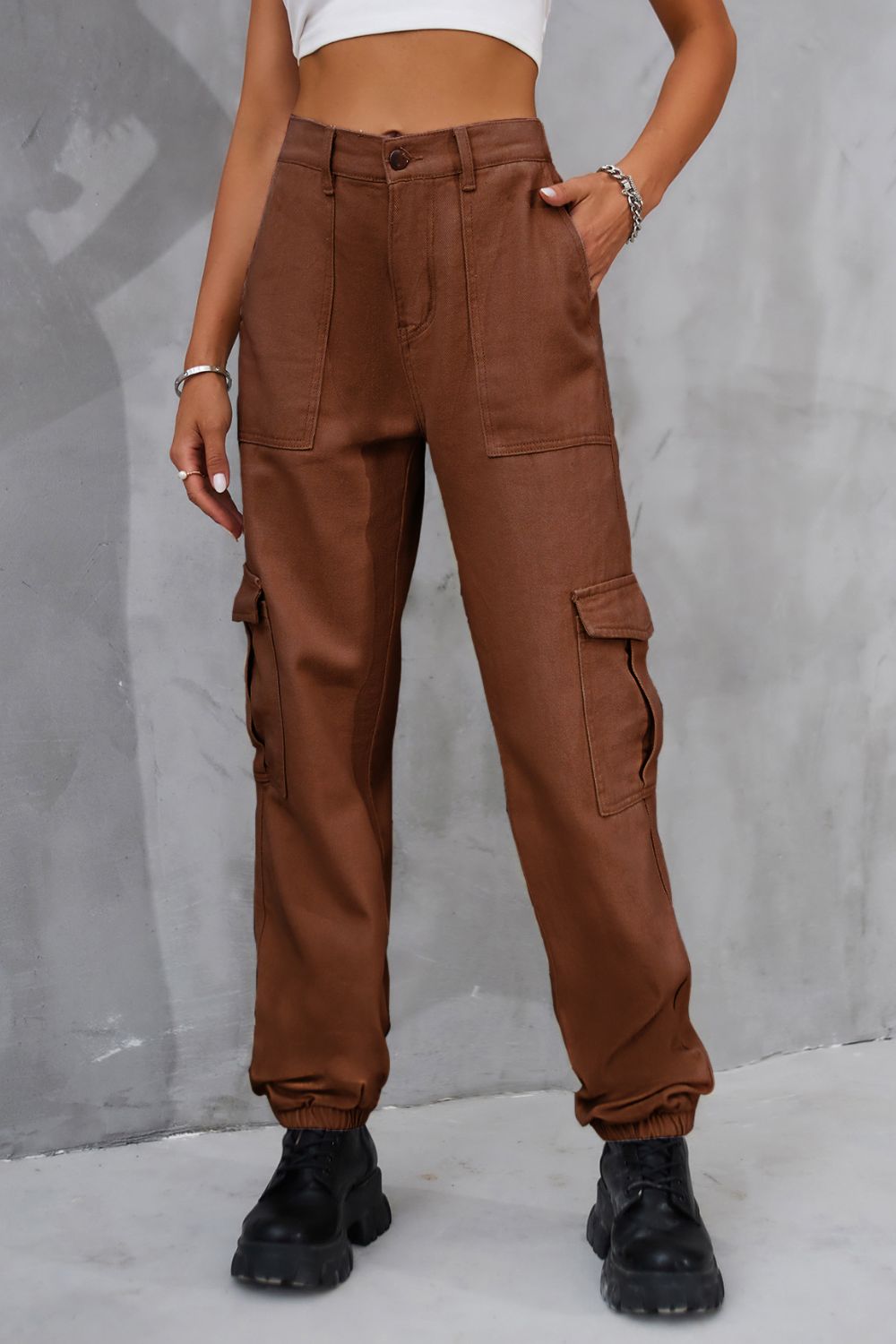 Brown buttoned high-waist cargo pants shown in a front view.
