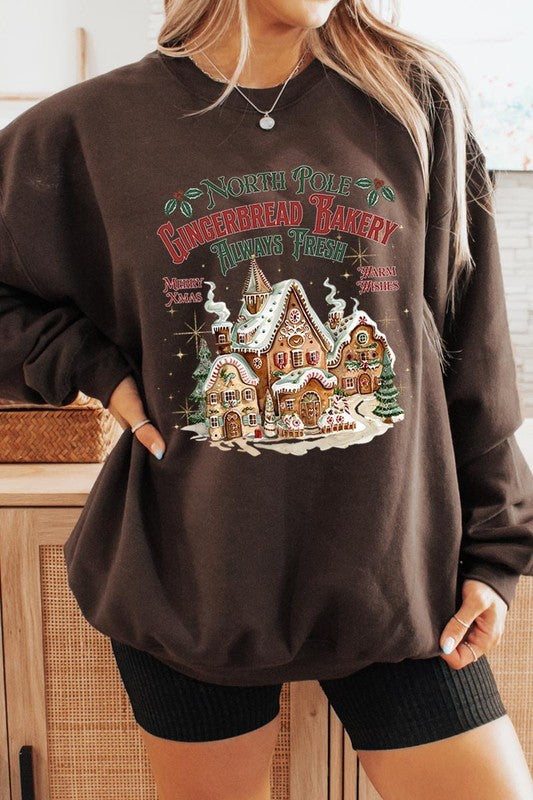 Warm brown sweatshirt with North Pole Gingerbread Bakery graphic for a cozy look.