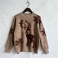 Front view of a cozy brown sweater featuring a playful reindeer and snowflake pattern.

