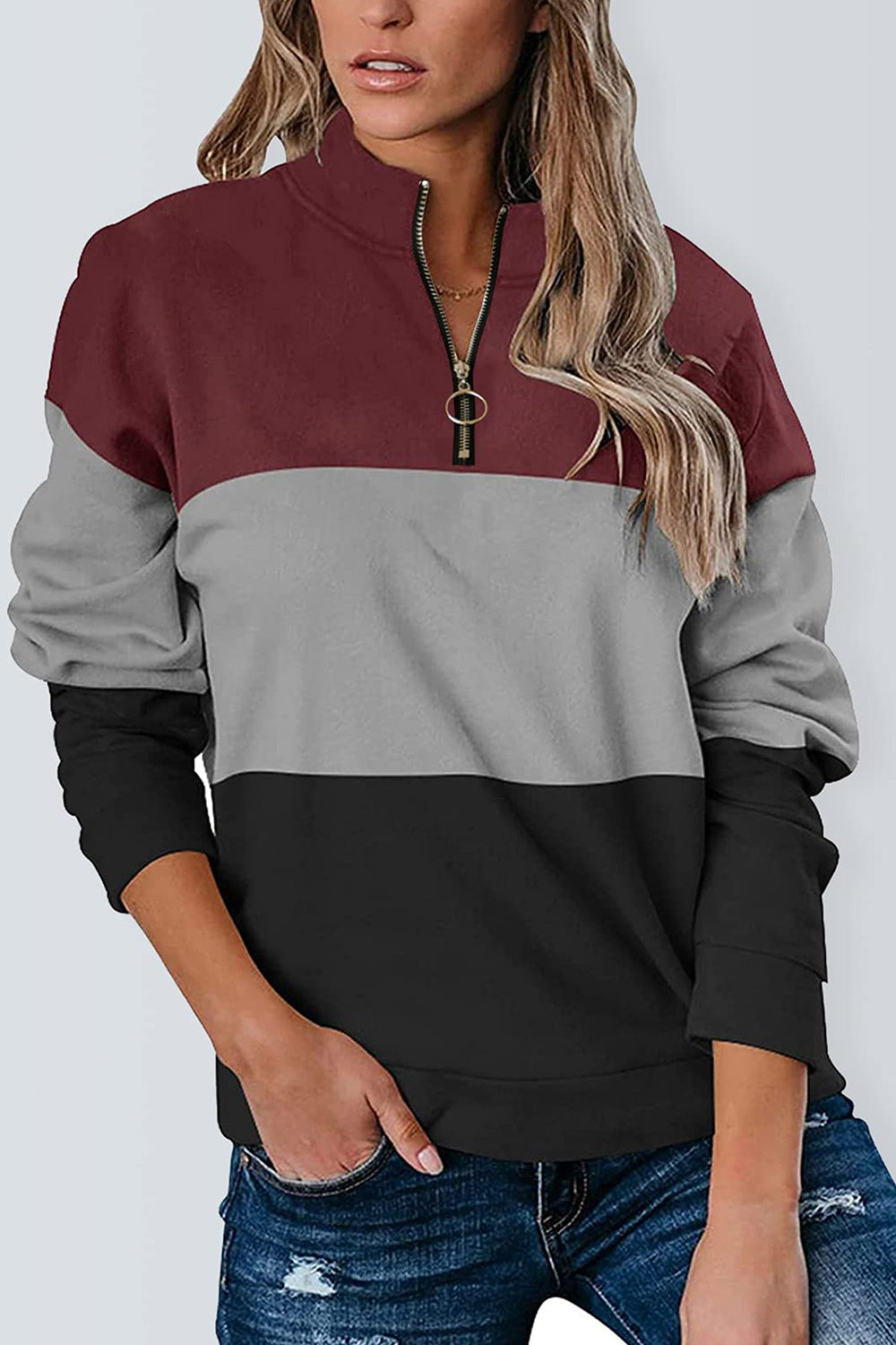 Burgundy, grey, and black color block half-zip sweatshirt styled casually.
