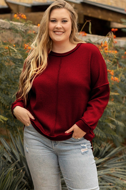 Plus-size burgundy waffle-knit top paired with light jeans for a casual look