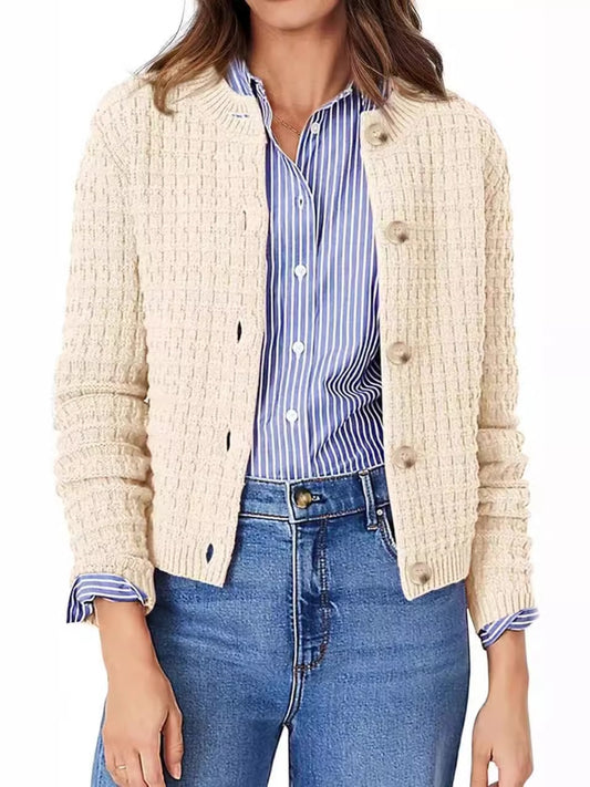 Front view of a beige knit cardigan styled over a white tee with light wash jeans.
