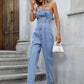 Woman wearing light wash button-front denim overalls with pockets.
