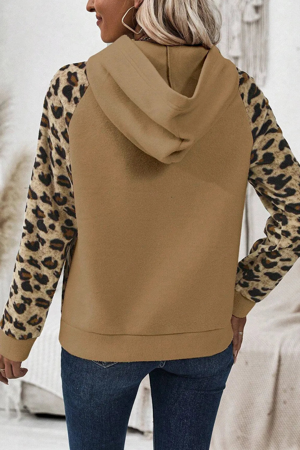 Trendy leopard print hoodie paired with dark skinny jeans for a casual look.
