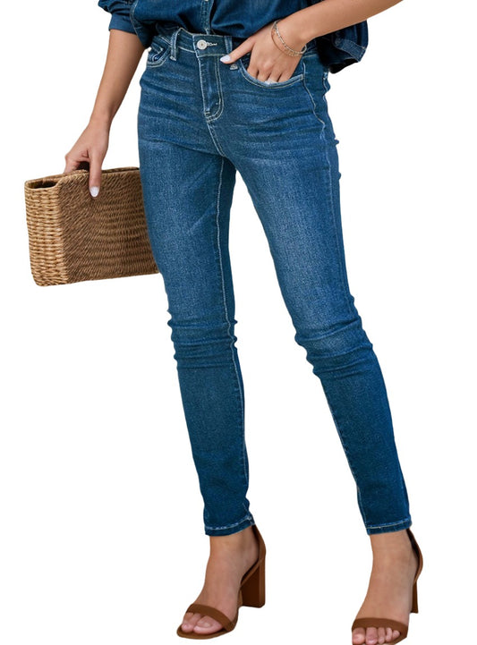 Front view of buttoned skinny jeans with pockets, featuring a model holding a woven handbag.