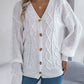 Classic white cable knit cardigan sweater with a cozy design and buttons.
