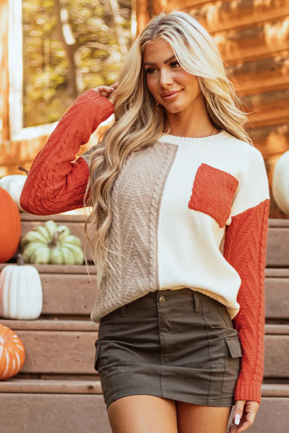 Cozy orange color block sweater featuring a front pocket and relaxed fit.
