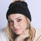 Cozy black winter beanie with braided texture and plush pom

