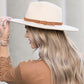 Camel wide brim Panama hat with a tassel belt shown from the side profile.
