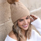 Trendy camel knit beanie with chunky texture and warm faux fur pom
