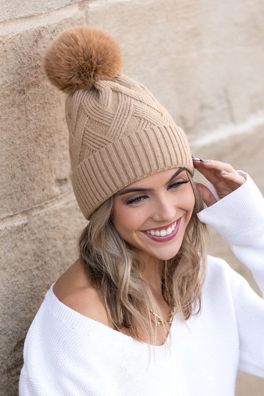 Trendy camel knit beanie with chunky texture and warm faux fur pom
