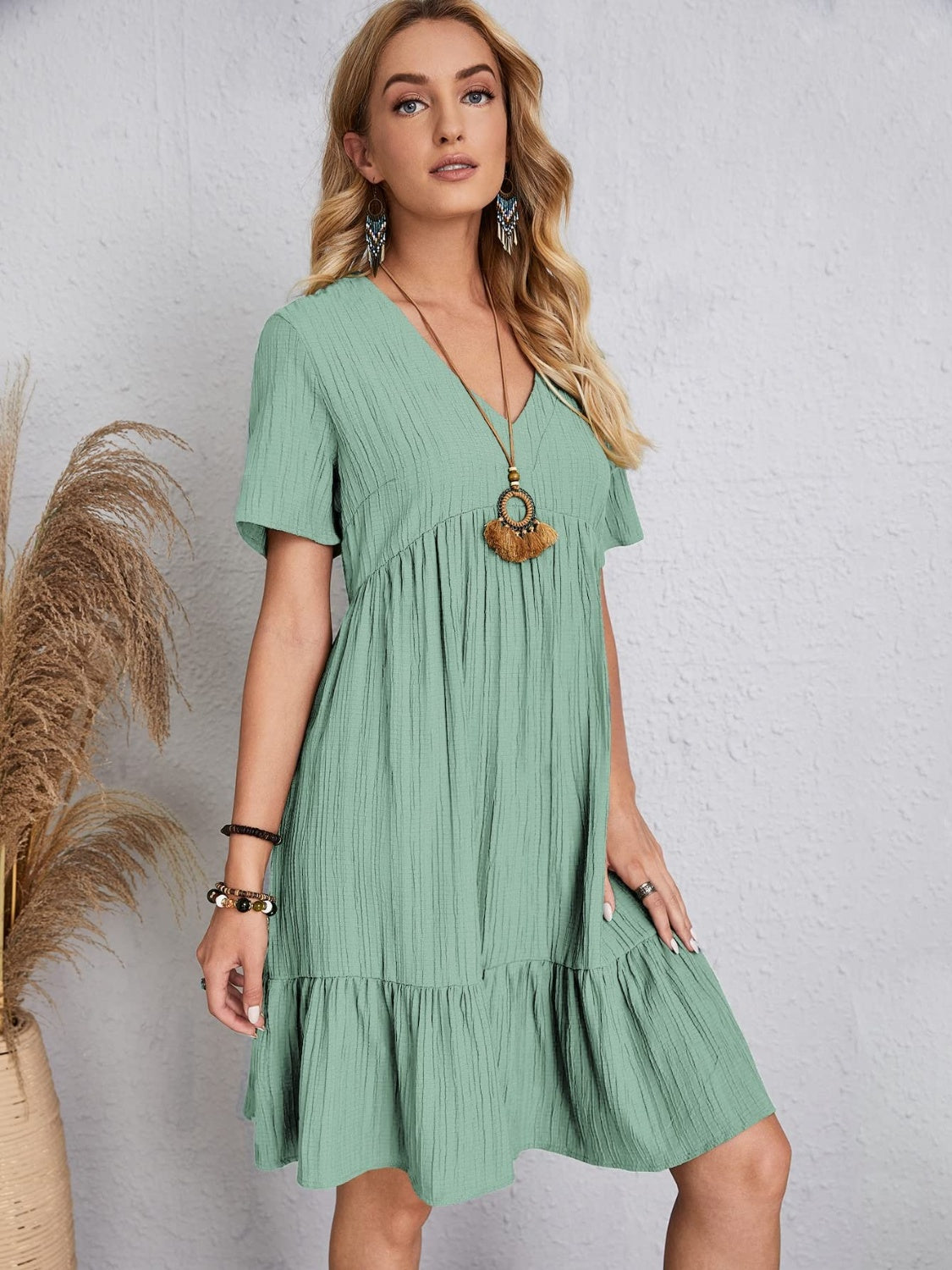 Relaxed fit green dress with playful tiered design

