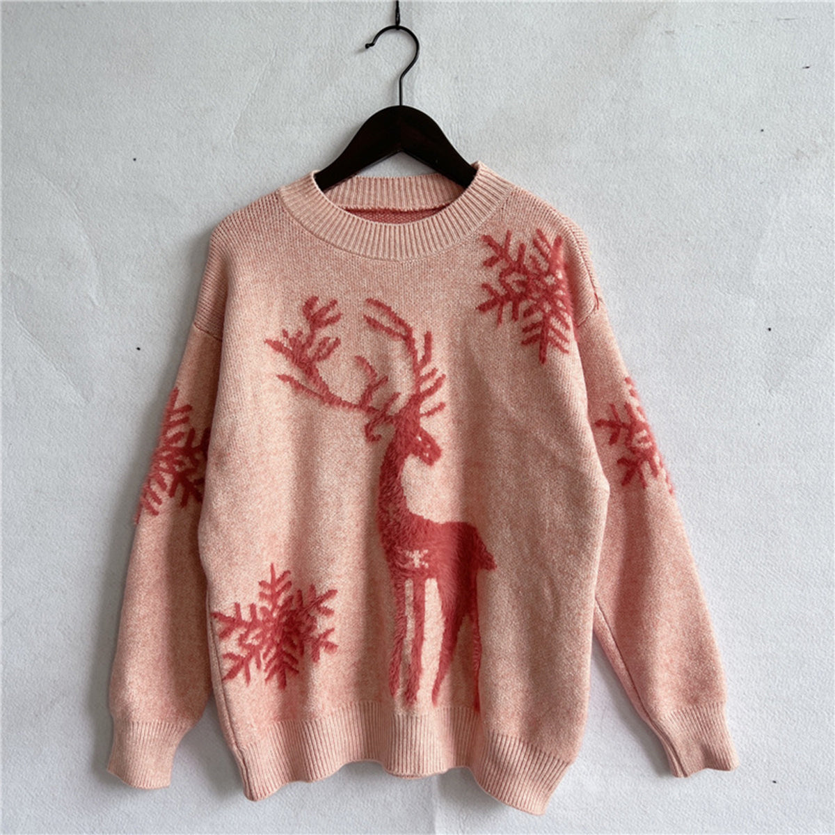 Casual blush reindeer sweater styled for cozy holiday gatherings and winter outings.

