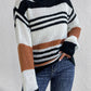 Woman in a relaxed-fit striped sweater with black and orange tones