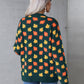 Casual green sweater adorned with orange fall leaves, great for cozy autumn days.
