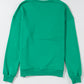 Women’s green casual holiday top featuring bold Merry print and relaxed sleeves.
