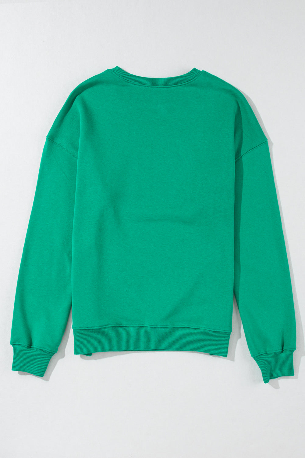 Women’s green casual holiday top featuring bold Merry print and relaxed sleeves.
