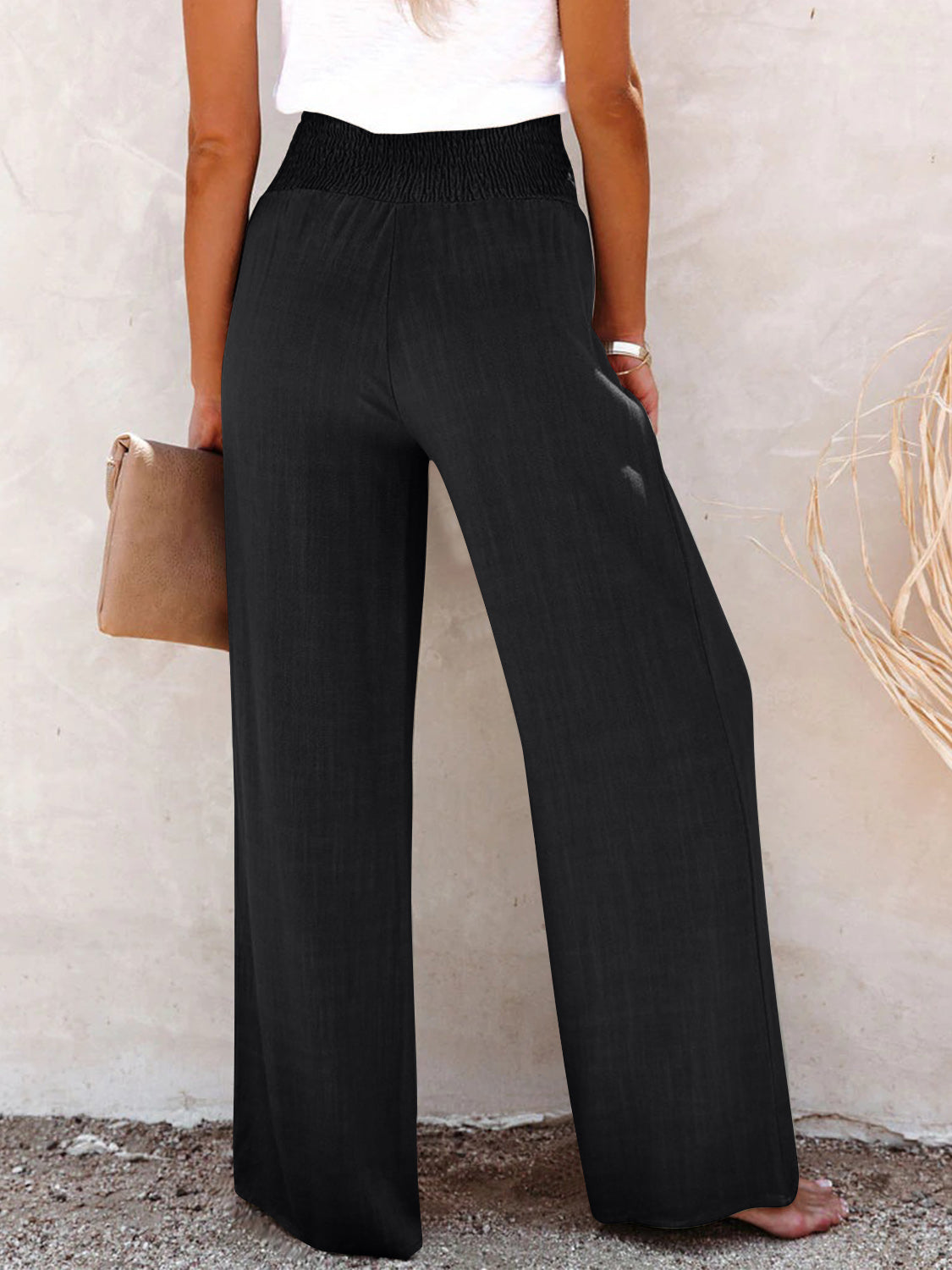 Stylish wide-leg pants for women in navy with button and smocked waist details.