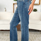 Women's mid-rise jeans in medium wash with a relaxed fit and edgy release hem.
