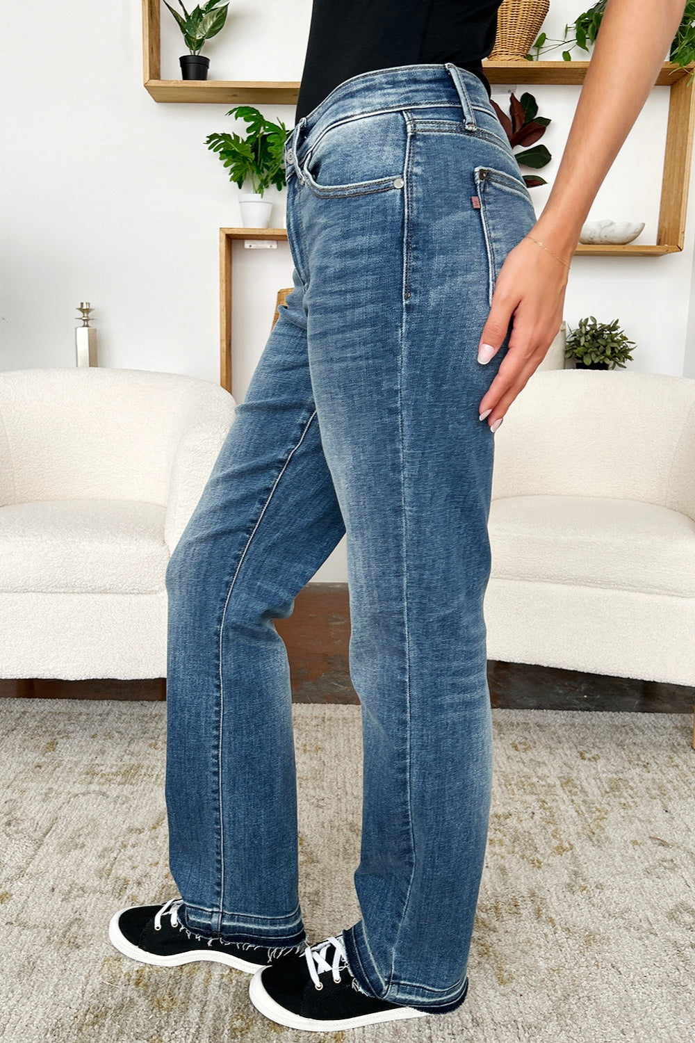 Women's mid-rise jeans in medium wash with a relaxed fit and edgy release hem.
