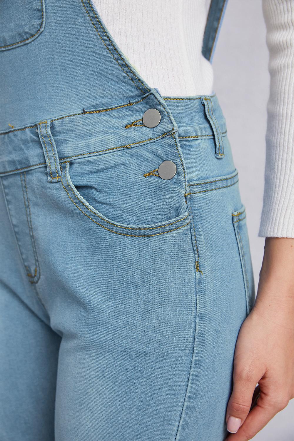 Light washed denim overalls with functional pockets and ripped details for women.
