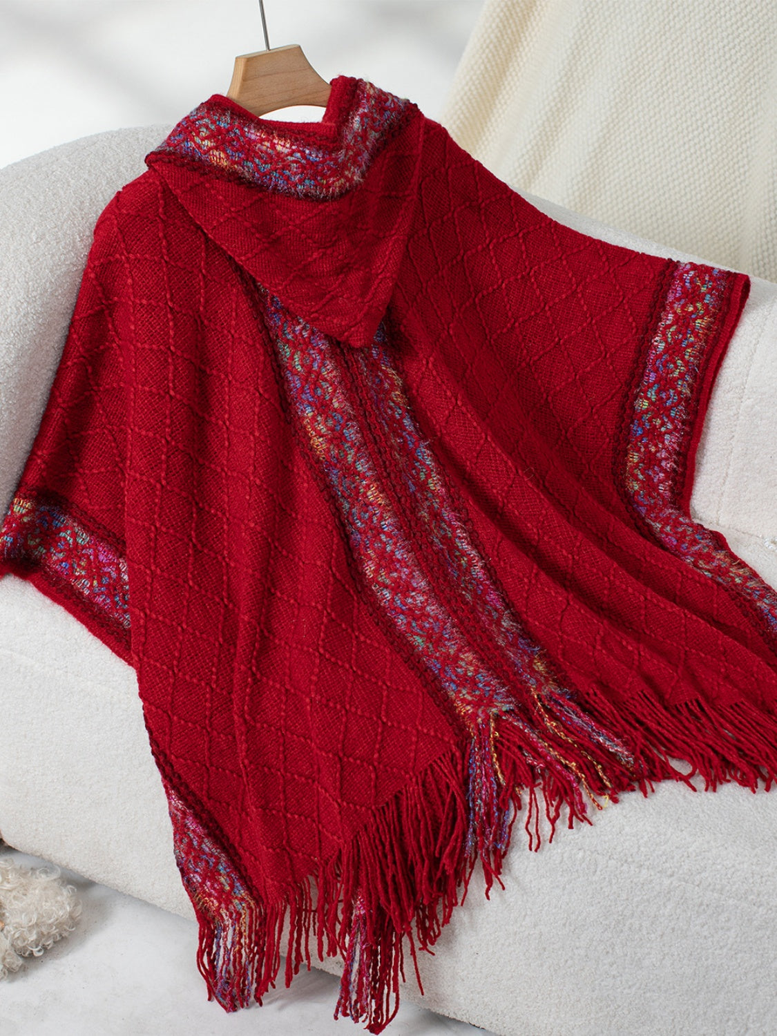 Burgundy poncho with hood and boho-inspired fringe
