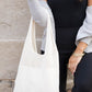 Lightweight cream knit hobo bag styled with a neutral outfit.
