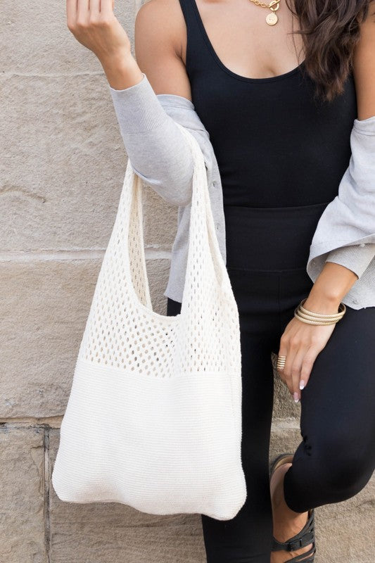 Lightweight cream knit hobo bag styled with a neutral outfit.
