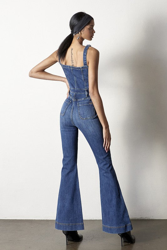 Flare leg denim jumpsuit with front button detailing and adjustable straps.
