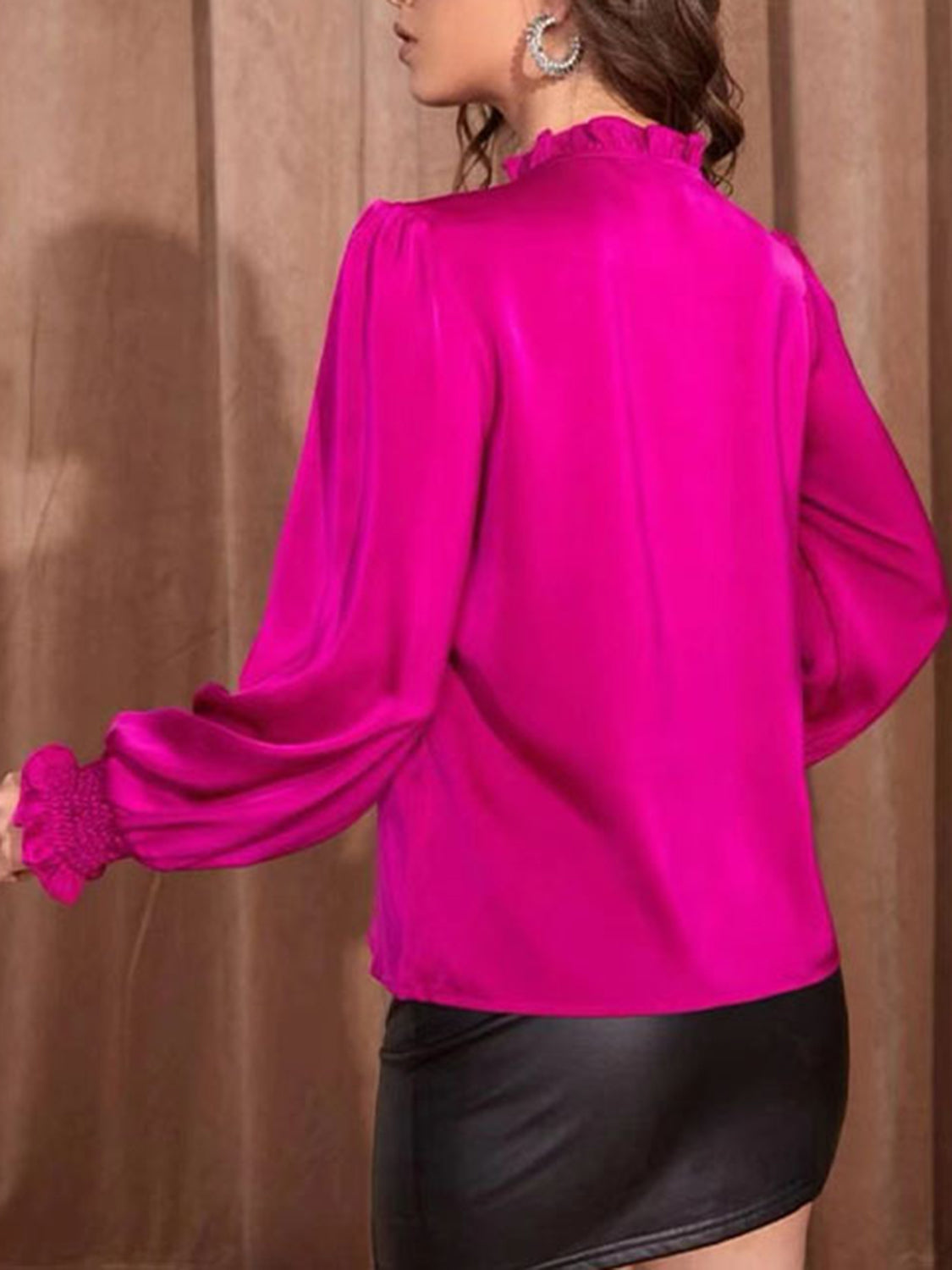 Women’s hot pink top with a tied neckline and dramatic sleeves.
