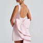 Chic pink formal dress featuring pearl embellishments and bow detail

