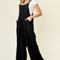 Textured cotton wide-leg overall paired with a white tee for a casual look.
