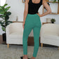 Trendy turquoise skinny pants featuring button accents on the front.