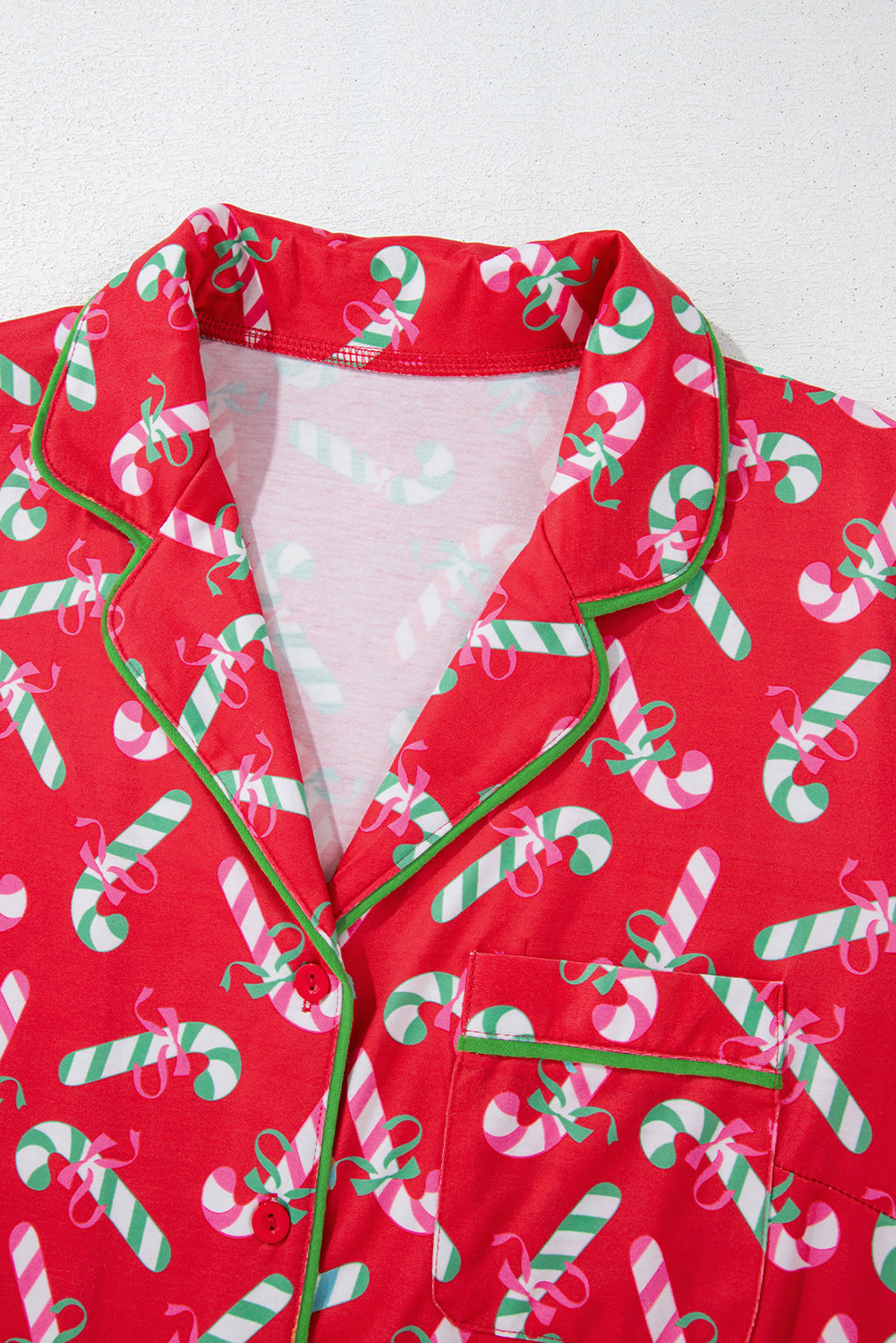 Detailed view of the Christmas pajama set, highlighting the candy cane print and knotted bow on the shorts.