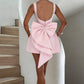 Women's pink dress with dramatic oversized bow and pearl accents

