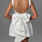 Pearl-trimmed white bow dress ideal for cocktail parties

