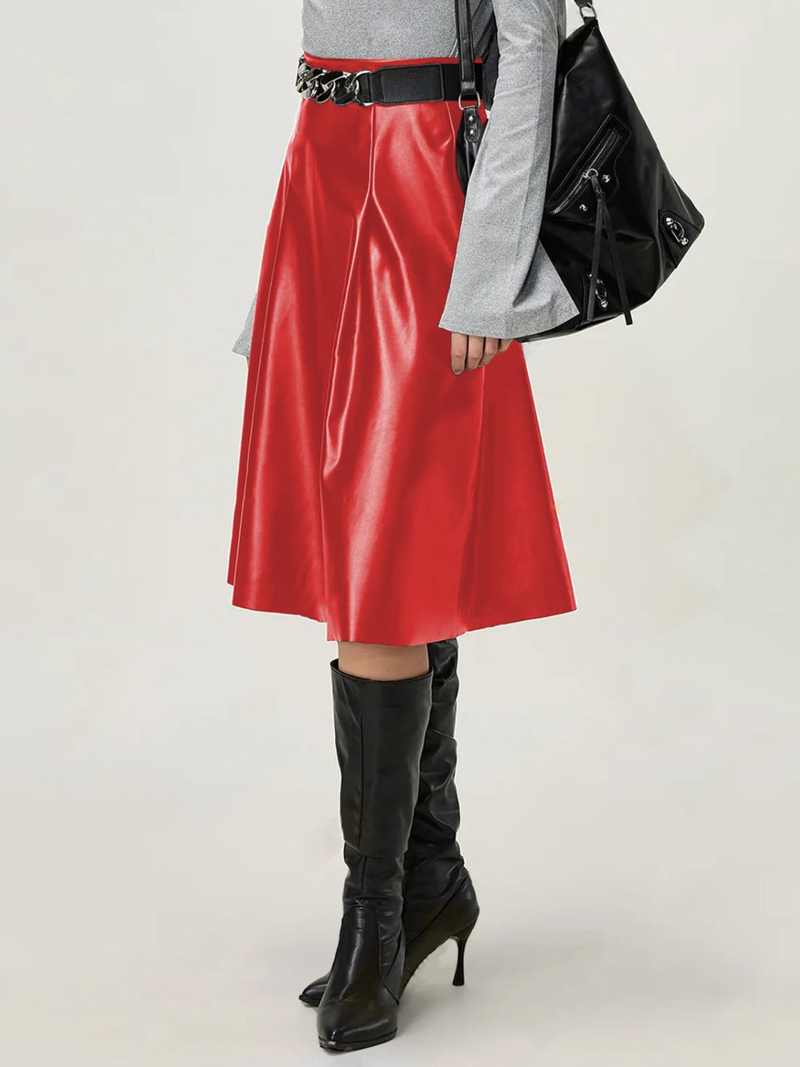 Close-up of red faux leather skirt, showing smooth finish and A-line shape.
