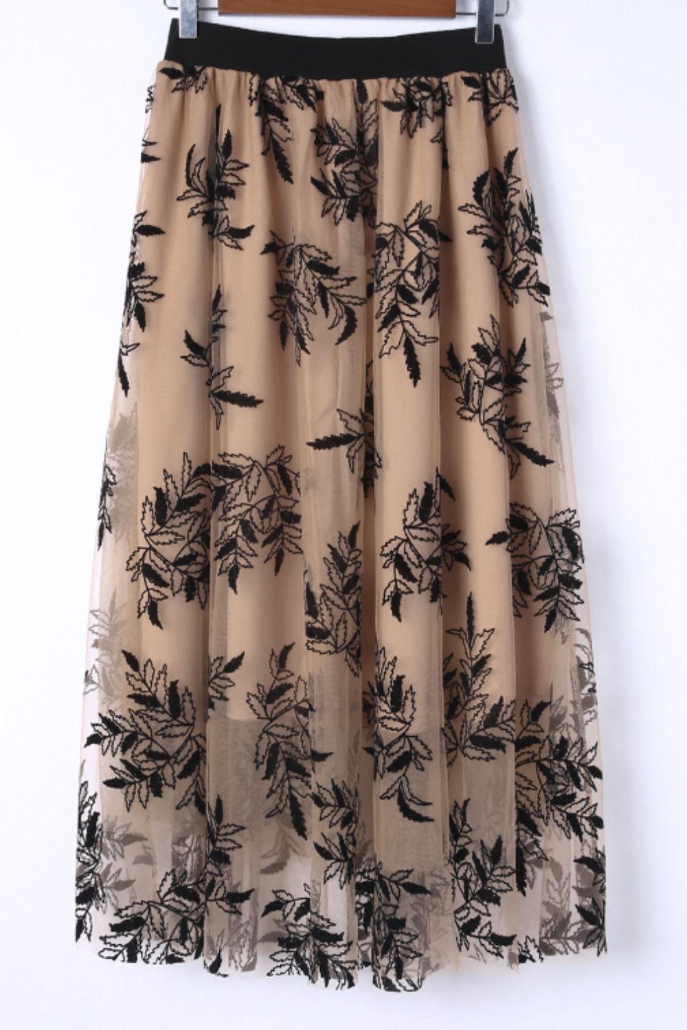 Feminine khaki mesh skirt with semi-sheer design and floral details.
