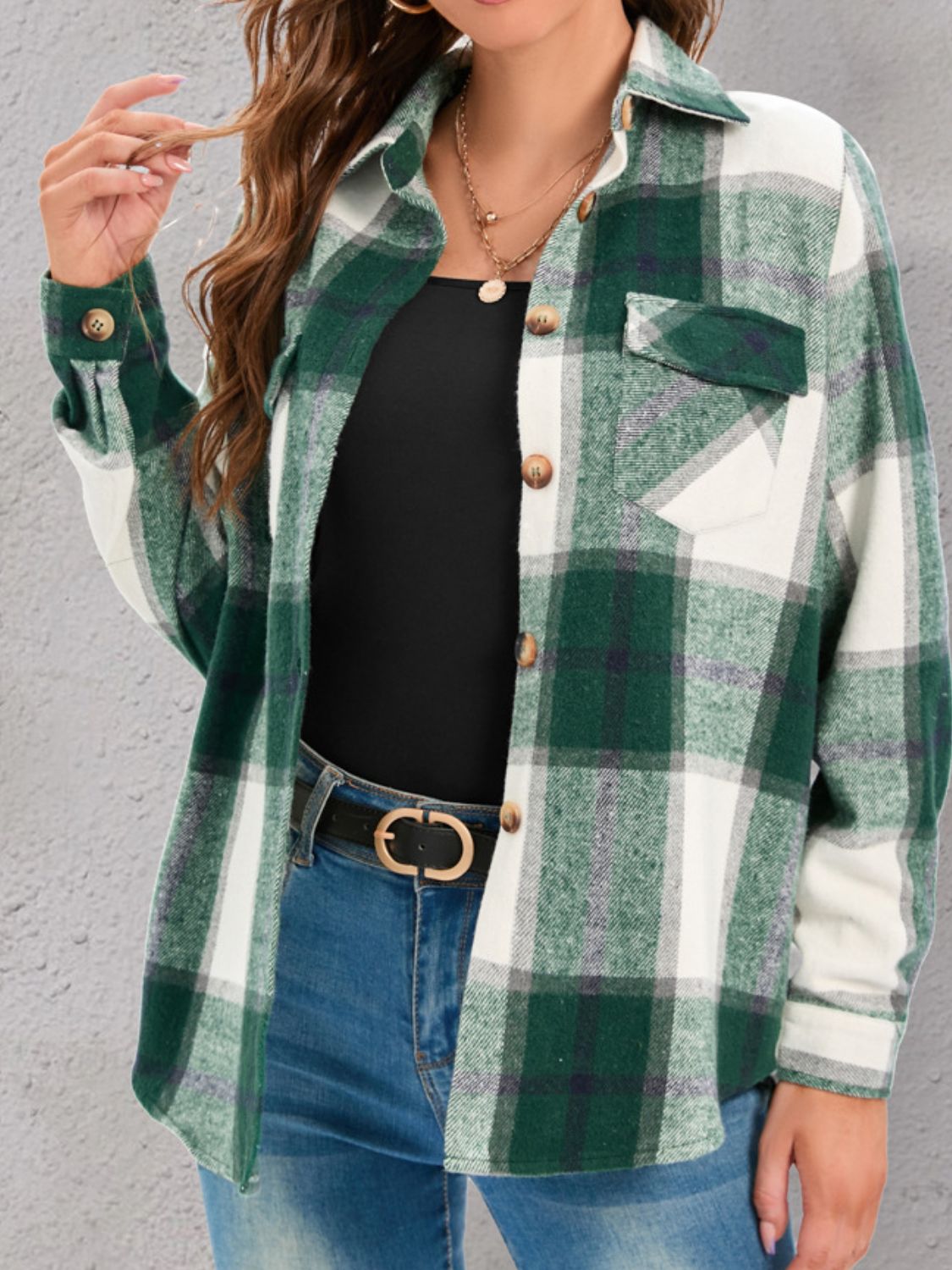 Green plaid shirt layered over a basic top and styled with casual jeans.
