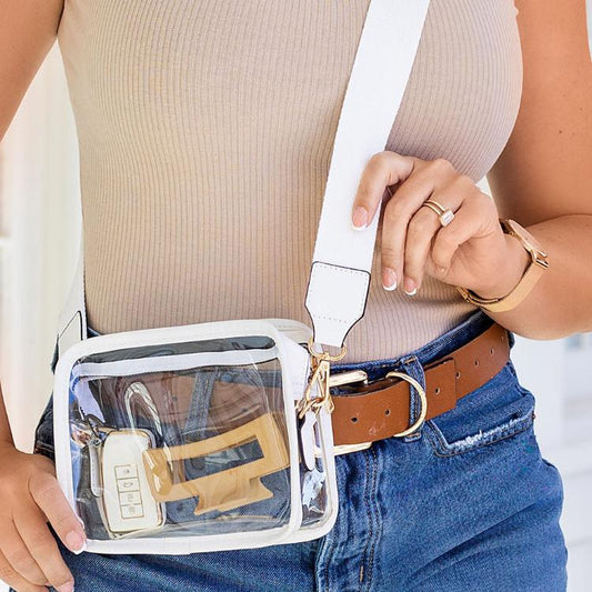 Clear crossbody bag with white trim and adjustable strap, front view.