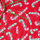 Close-up showing the detailed candy cane print and green trim on this festive pajama set.
