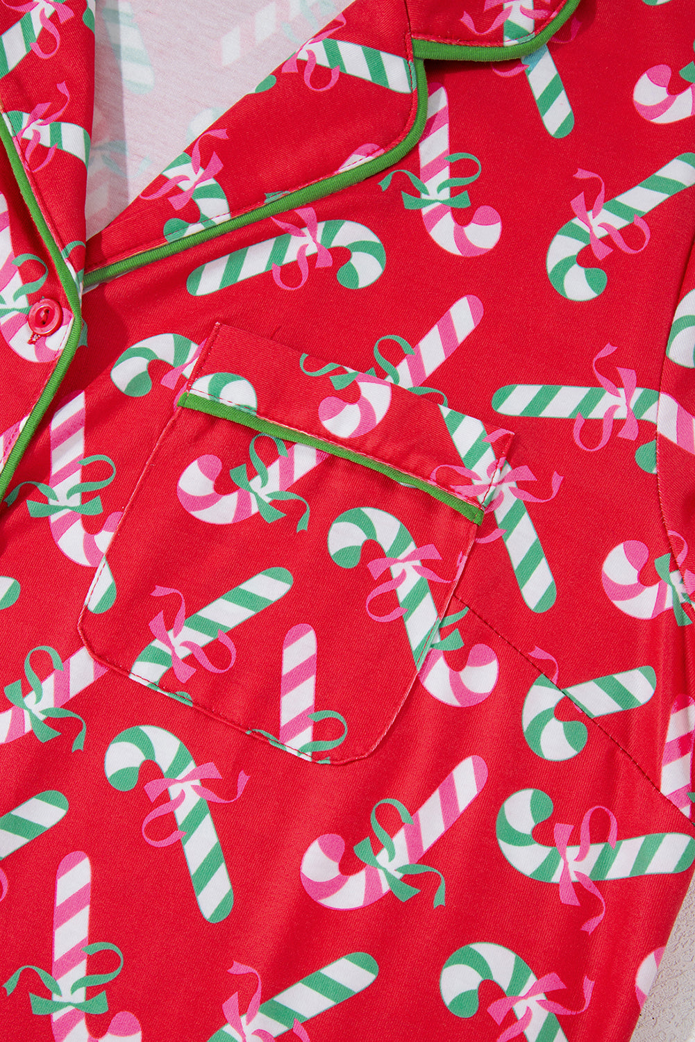 Close-up showing the detailed candy cane print and green trim on this festive pajama set.
