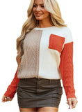 Woman wearing color block cable knit sweater in orange with front pocket.
